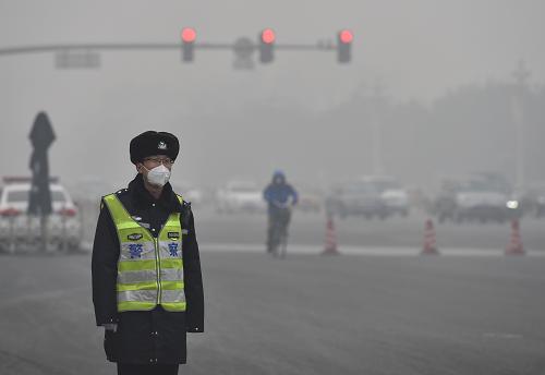 11月30日，一名交警戴著口罩在北京長安街上執(zhí)勤。