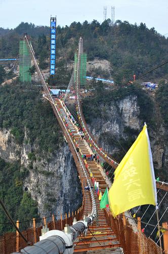 施工中的張家界大峽谷玻璃橋（12月3日攝）。12月3日，隨著最后一片重達(dá)41噸加勁梁的精準(zhǔn)吊裝，湖南張家界大峽谷玻璃橋鋼箱梁成功合龍。據(jù)悉，張家界大峽谷玻璃橋總長430米、寬6米，橋面距離谷底相對高度約300米。橋面全部采用透明玻璃鋪設(shè)，最大游客容量為800人。目前，大橋建設(shè)進(jìn)入施工尾期，預(yù)計(jì)2016年“五一”節(jié)前對外開放。新華社記者 龍弘濤 攝