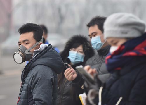 12月8日，戴著口罩的市民在通州區(qū)一處公交車站候車