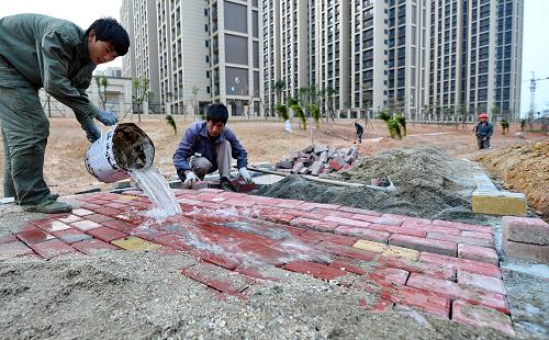 工人在廈門翔安“海綿城市”建設(shè)示范點(diǎn)——旱溪公園鋪設(shè)透水磚（12月16日攝）。