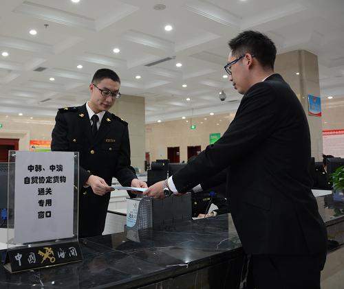 12月20日，貨代公司工作人員向青島大港海關(guān)工作人員遞交《中韓自貿(mào)協(xié)定》正式生效后中國首票進(jìn)口貨物報(bào)關(guān)單。