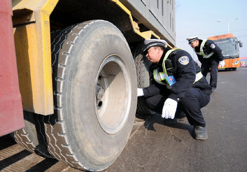 2月3日，在河北省S222省道沙河段白塔春運安檢服務站，沙河市交警大隊民警對危險品運輸車輛的輪胎進行檢查。新華社記者 朱旭東 攝