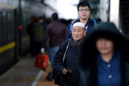 2月12日，西寧火車站，來自青?；〉幕刈謇先笋R三元（右二）準備乘車前往武昌，他在武昌經(jīng)營著一家拉面館。新華社記者 張宏祥 攝