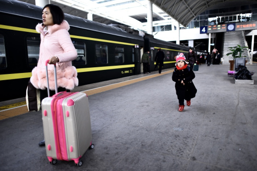 2月12日，在西寧火車站，一名小朋友跟隨母親乘車前往廣州。新華社記者 張宏祥 攝