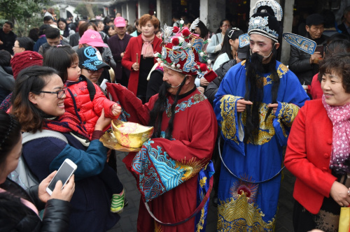 2月12日，“財神”送福隊伍在西塘古鎮(zhèn)為游客送去祝福，民間傳說正月初五是財神的生日。新華社記者 黃宗治 攝