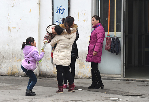 2月13日，在安德門民工就業(yè)市場(chǎng)內(nèi)，中介人員（右一）向兩名帶孩子的求職者推介崗位。