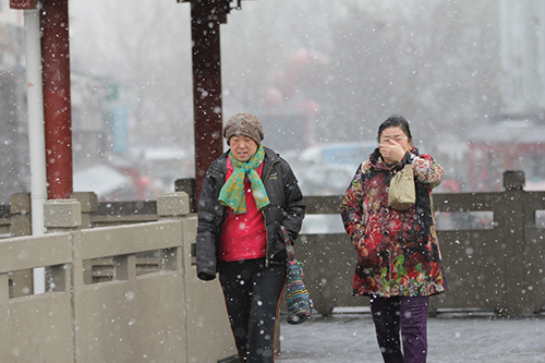 2月14日，青島市民冒雪出行。2月11日至14日，受寒潮影響，我國(guó)中東部地區(qū)大風(fēng)降溫和雨雪天氣持續(xù)。中央氣象臺(tái)14日18時(shí)繼續(xù)發(fā)布寒潮黃色預(yù)警。