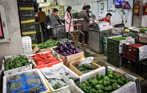 2月16日，工人在深圳海吉星批發(fā)市場搬運(yùn)蔬菜。新華社記者 毛思倩 攝