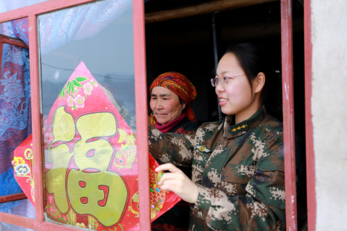 2月19日，邊防派出所民警和熱合木·別爾地的妻子一同在貼“福”字。新華社發(fā)（賈航超 攝）