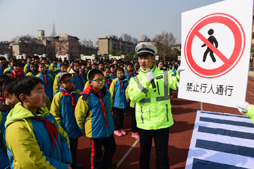 2月25日，學生們在交警的指導(dǎo)下識別交通標志。