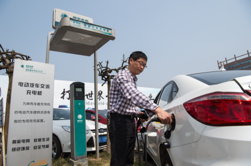 3月18日，一名車主在重慶市內(nèi)一處停車場使用國網(wǎng)重慶市電力公司的充電樁為新能源電動汽車充電。新華社記者 劉潺 攝