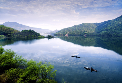 清晨，霍山縣群眾在佛子嶺庫(kù)區(qū)駕小船前行（4月9日攝）。四月，大別山腹地的安徽省霍山縣一片春光明媚景色，青翠的山巒云蒸霞蔚，漫山遍野的映山紅絢麗似火，處處是春的涌動(dòng)。佛子嶺、屋脊山、黑虎尖等大自然美景，已成為游人踏青、觀花、旅游、攝影的好去處。新華社發(fā)（徐程 攝）