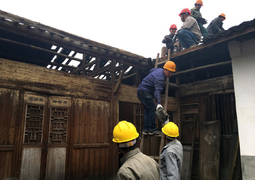 4月14日，在浙江麗水市松陽縣山下陽村，工作人員取下老屋屋頂瓦片，準(zhǔn)備進(jìn)行修繕。